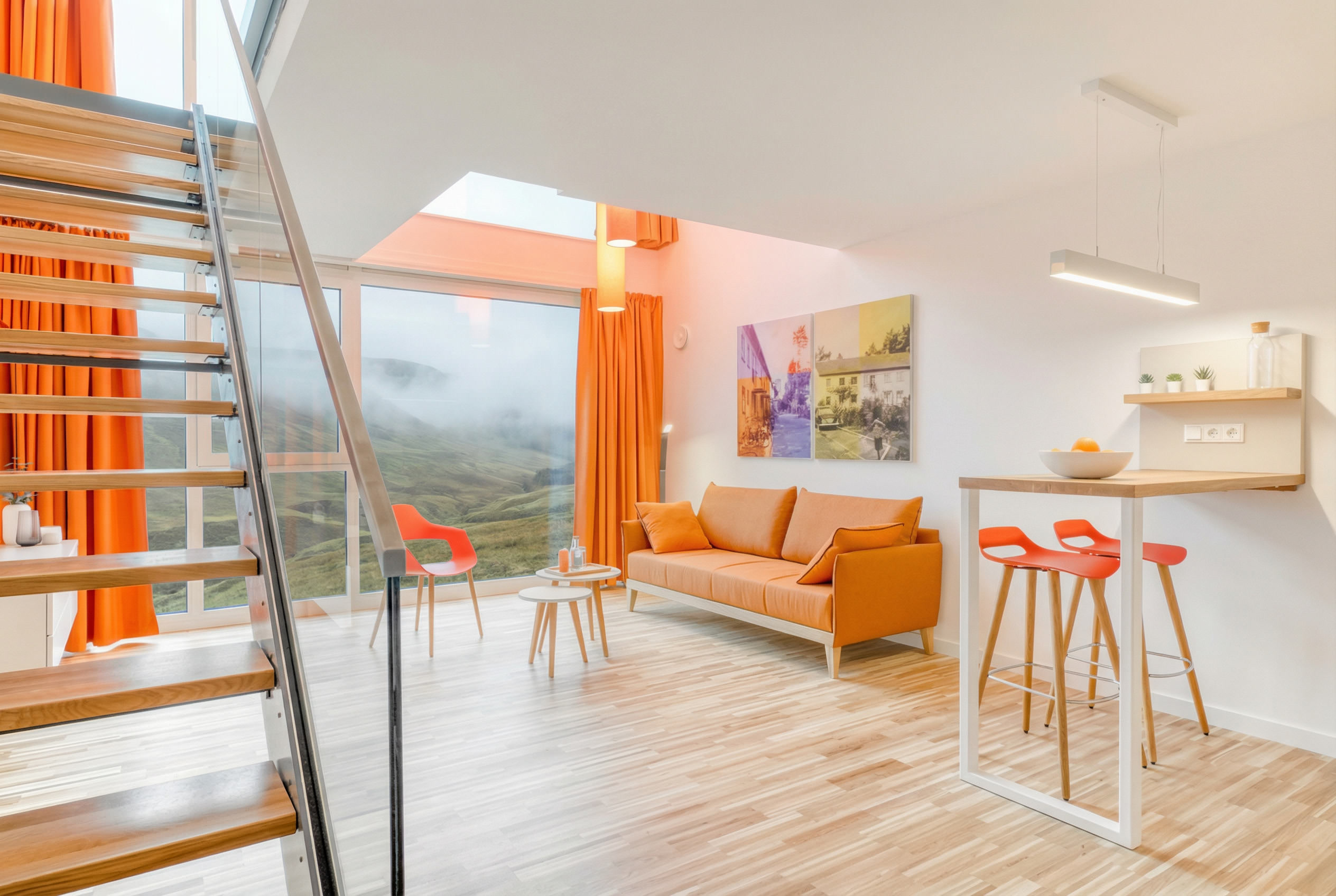Moderne Hotel-Suite im Loftstil mit Treppe, großen Fenstern und orangefarbenem Sofa